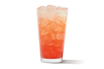 Premium Strawberry Lemonade in a glass, bright pink in color, topped with fresh strawberries and a lemon slice.